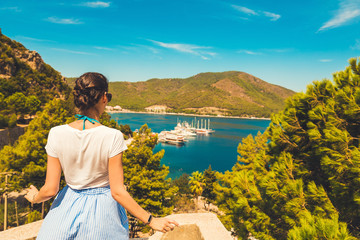 Girl follow me, looking panoramic beautiful view berth of marina. In the Turkish city of Icmeler. View of the island in the bay