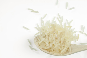 Jasmine rice on a wooden spoon isolated on a white background. Selective focus.