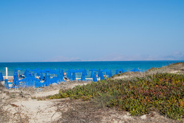 Parasol and sunbeds on the beach of the island of Kos