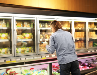 Man choosing frozen food from a supermarket freezer