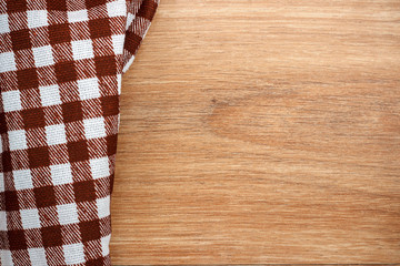 Brown checkered tablecloth, wooden table, top view