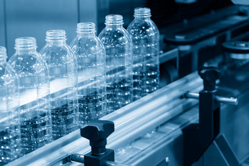 The plastic bottles on the conveyor belt at the drinking water factory. Drinking water...