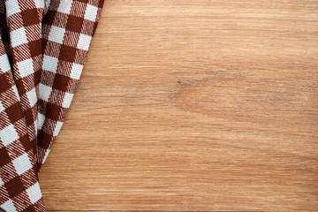 Brown checkered tablecloth, wooden table, top view