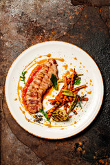 Delicious sliced grilled duck breast with fresh sauce.  closeup of professionally prepared food.