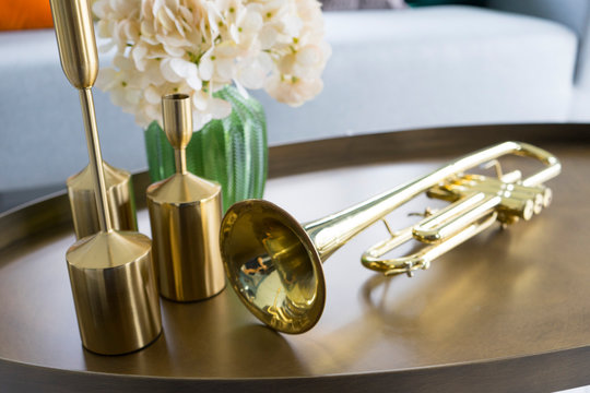 colorful and stylish living room with flower vase and gold trumpet on table. 