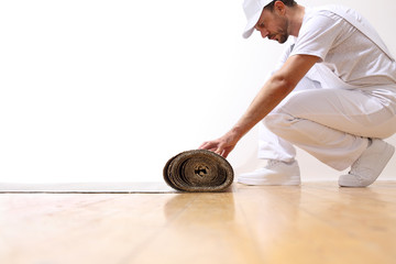 painter man at work, rolls the cardboard on the floor, copy space template