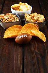 Chips, salty snacks, football on a table. Great for Bowl Game