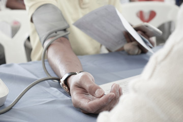 Volunteer checking man Risk group arterial blood pressure. Health care.