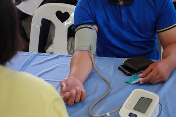 Volunteer checking man Risk group arterial blood pressure. Health care.