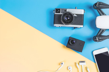 Hi tech travel gadget and accessories on blue and pink copy space with drone action camera