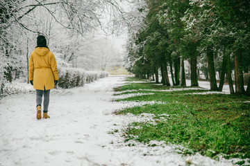 Fototapeta na wymiar woman walk by park where winter meet spring