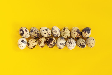 Obraz na płótnie Canvas Quail eggs on yellow paper background. Easter concept. Template Creative Flat lay Top view Copy space lettering, text or your design