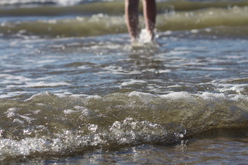 Sea water and female legs at the background.