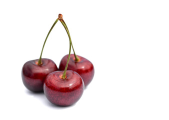 Three cherries isolated on a white background.