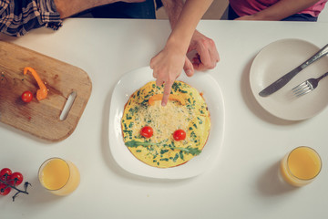 Bearded tall man in a checkered shirt and his daughter having fun at the breakfast