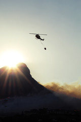 Fototapeta na wymiar Fire helicopters fighting a growing wildfire on the 27th of January 2019 at Lion's Head in Cape Town, South Africa