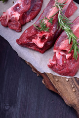 Raw beef ribs, rosemary, thyme and spices on a wooden board