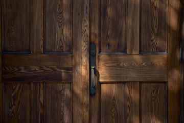 Old wooden closet door slightly open. Natural light.