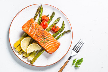 Grilled salmon fish fillet with asparagus on white. 
