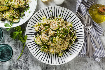 salad with rice with zucchini, avocado, olives and capers. healthy spring summer vegan cuisine recipe for the whole family or party