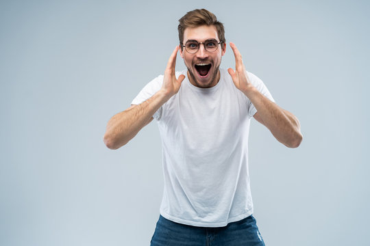 Portrait Of Young Amazed Man Isolated On Gray Background.