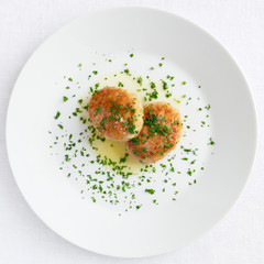 fried breaded chicken patties with butter and chopped parsley