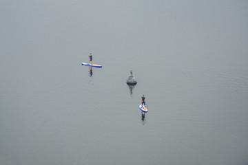 Two people surfing on a calm river