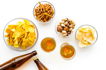 Snacks and beer. Chips, nuts, rusks near beer on white background top view