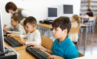 Fototapeta premium Tween boy during lesson in computer room