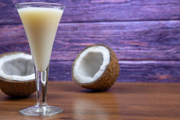 Pina Colada liqueur in a glass and two coconut halves