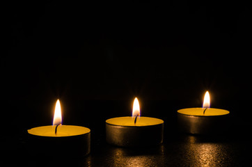 Obraz na płótnie Canvas Three burning candles isolated on black background.