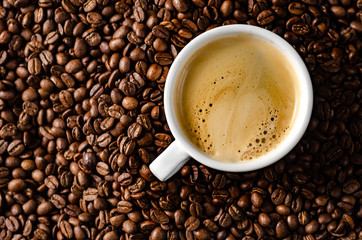 coffee beans background with white cup, copy space