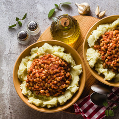 mashed potatoes with stewed white beans in tomatoes. winter warming recipe from vegan cuisine