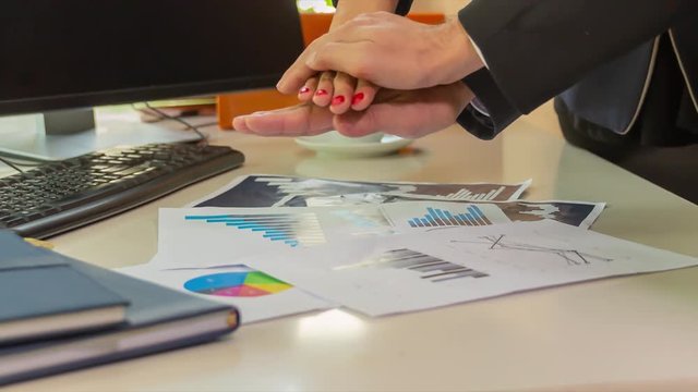 Close up scene of businesspeople stacks hand on office working desk, team work and success concept.