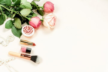 Women's makeup products, accessories  and  pink flowers roses top view on pale pink background. Flat lay women accessories.Copy space