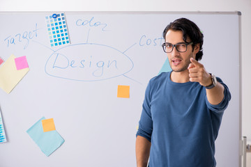 Young handsome designer working at the project  