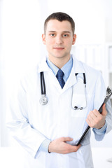 Smiling doctor waiting for his team while standing upright