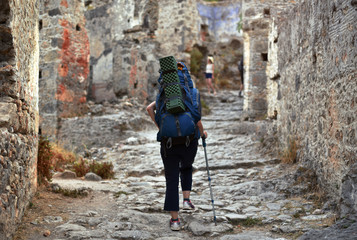 Obraz na płótnie Canvas hiker woman walking by ruins of ancient city Kayakoy
