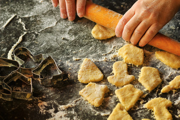 Closeup of woman's hands working with dough and making biscuits