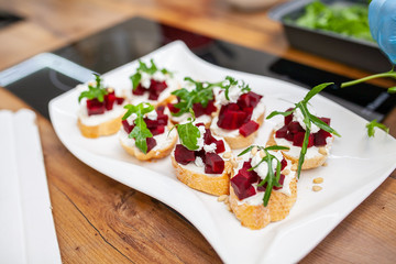 bruschetta with cheese and beetroot on a white plate