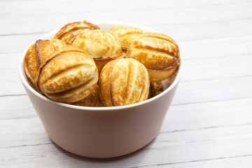 Close-up bowl with cookies - nuts on a light wooden background