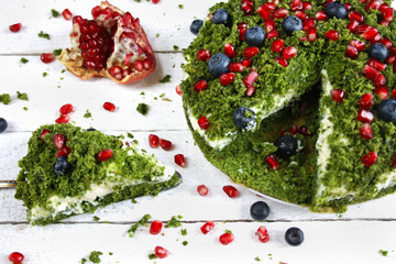 Ciasto "zielony mech" ze szpinakiem ozdobione pestkami granatu i jagodami