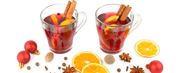 Hot red mulled wine isolated on white background with spices, orange slice, anise and cinnamon sticks. Flat lay, top view.Wide photo.