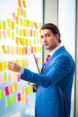 Young handsome employee with many conflicting priorities   