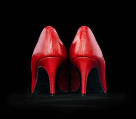 Elegant women's shoes made of red leather on a black background
