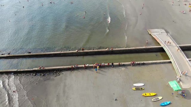 A Beach with a Canel and people in water - Top View - Dolly Forward 