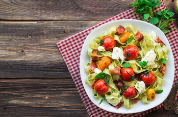 Fettuccine pasta with baked tomatoes, bacon and mozzarella cheese