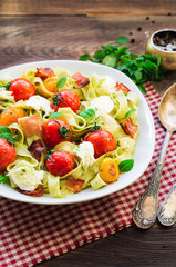 Fettuccine pasta with baked tomatoes, bacon and mozzarella cheese