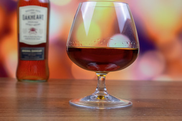 Rum in a glass and a bottle in the background