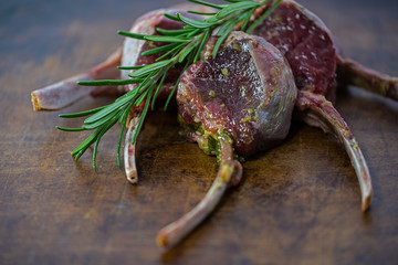 raw lamb chop ready to roast, garnished with a branch of romarin